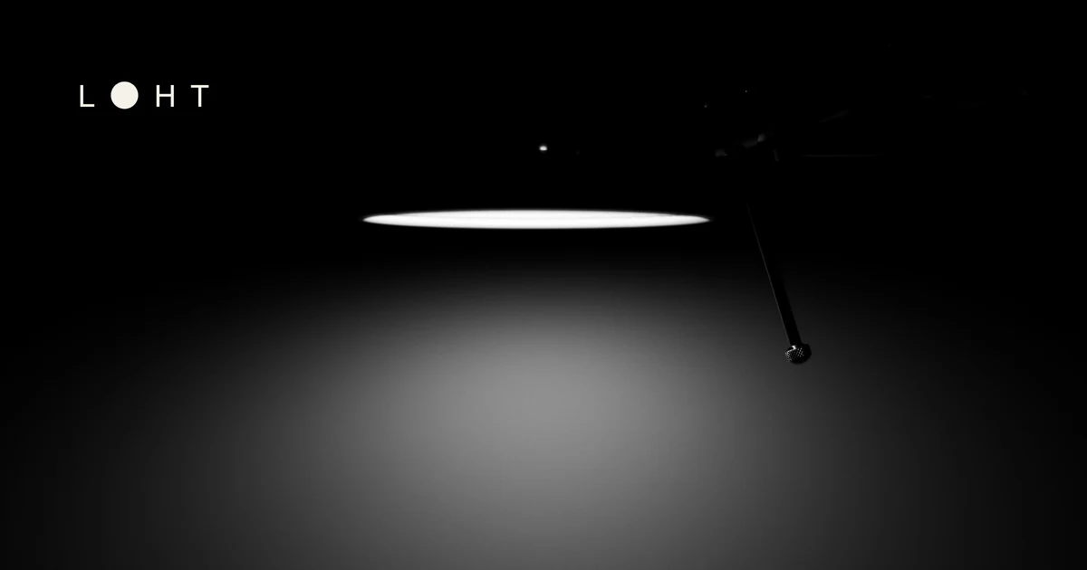 Schwarzweißaufnahme einer eingeschalteten Lampe vor dunklem Hintergrund