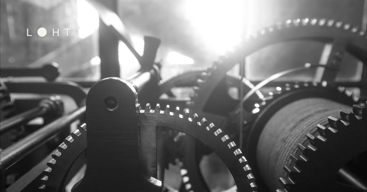 Schwarzweißaufnahme eines mechanischen Uhrwerks mit Zahnrädern